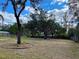 Spacious backyard with mature trees and a partially fenced area at 10448 Canary Ave, Weeki Wachee, FL 34613