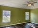 Bedroom with two windows, wood-look floors, and a ceiling fan at 10448 Canary Ave, Weeki Wachee, FL 34613