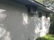 Side exterior view of the house showing the AC unit, neutral color scheme, and windows at 12266 Birch St, Brooksville, FL 34613