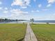 Landscaped backyard with a pathway leading to the waterfront at 1904 Gulfview Dr, Holiday, FL 34691