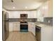 Modern kitchen with white shaker cabinets, stainless steel appliances, and quartz countertops at 4540 Flora Ave, Holiday, FL 34690