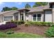 Landscaped front yard with manicured shrubs and a brick house with screened garage at 7425 Baywood Forest Cir, Spring Hill, FL 34606