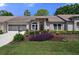 Brick house with landscaped front yard, two-car garage, and screened entryway at 7425 Baywood Forest Cir, Spring Hill, FL 34606