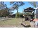 Spacious backyard with various sheds, lush trees, and open space, creating a serene outdoor environment at 8700 Ross Ln, New Port Richey, FL 34654