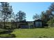 Wooden barn with gated enclosure in the backyard at 8700 Ross Ln, New Port Richey, FL 34654