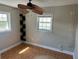 This bedroom features a ceiling fan and natural light at 8700 Ross Ln, New Port Richey, FL 34654