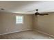 An interior view of a bedroom with a ceiling fan and window that allows plenty of light at 8700 Ross Ln, New Port Richey, FL 34654