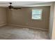 A roomy bedroom featuring wall-to-wall carpet, a ceiling fan, and a window at 8700 Ross Ln, New Port Richey, FL 34654