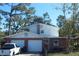 Exterior view of a two-story home with brick accents, a two car garage and a neatly kept lawn at 8700 Ross Ln, New Port Richey, FL 34654