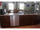 Open kitchen with stainless steel dishwasher, granite countertop and wood finish cabinets at 8700 Ross Ln, New Port Richey, FL 34654