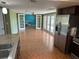 Open-concept living room with tile floors, French doors, and modern appliances from kitchen view at 8700 Ross Ln, New Port Richey, FL 34654