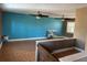Spacious living room featuring tile flooring, ceiling fans, and a bright teal accent wall at 8700 Ross Ln, New Port Richey, FL 34654