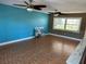 Bright living room with tile flooring, ceiling fans, and a blue accent wall, perfect for entertaining at 8700 Ross Ln, New Port Richey, FL 34654