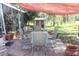 Relaxing patio with seating area, shade cover, and view of the backyard at 8700 Ross Ln, New Port Richey, FL 34654