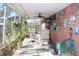 Enclosed patio features brick wall with fun decor, tile flooring, and outdoor seating, perfect for relaxing at 8700 Ross Ln, New Port Richey, FL 34654