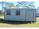 This outdoor shed has two windows and a Personal door allowing natural light and easy entry at 8700 Ross Ln, New Port Richey, FL 34654