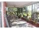 Enclosed sunroom with brick accent walls, ceiling fan, tile flooring, and views of the lush landscape at 8700 Ross Ln, New Port Richey, FL 34654