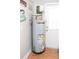 Utility room featuring a modern water heater with safety features and access to a back door at 8700 Ross Ln, New Port Richey, FL 34654