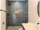 Shower with gray tile and pebble floor at 9053 Nakoma Way, Weeki Wachee, FL 34613