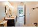 Modern bathroom with double vanity, herringbone floor, and view to pool at 9053 Nakoma Way, Weeki Wachee, FL 34613