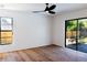 Bright bedroom with hardwood floors, ceiling fan, and sliding glass doors to backyard at 9053 Nakoma Way, Weeki Wachee, FL 34613