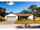 Updated single-story home with a large driveway and landscaped lawn at 9053 Nakoma Way, Weeki Wachee, FL 34613
