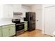 Modern kitchen with stainless steel appliances and green cabinets at 9053 Nakoma Way, Weeki Wachee, FL 34613