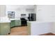 Modern kitchen with green cabinets, quartz countertops, and stainless steel appliances at 9053 Nakoma Way, Weeki Wachee, FL 34613