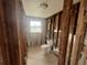 A gutted bathroom ready for renovation with exposed framework, concrete flooring, and a toilet at 13639 Frances Ave, Hudson, FL 34667