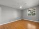 Bright bedroom features light gray walls, ceiling fan, wood floors, and sunlit window at 230 Thorn Tree Pl # 230, Brandon, FL 33510