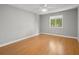 Bright bedroom featuring wood floors, a ceiling fan, and a large window overlooking the outside at 230 Thorn Tree Pl # 230, Brandon, FL 33510