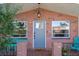 Brick front porch with teal chairs and a blue door at 3104 Domino Dr, Holiday, FL 34691