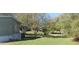 Side yard of the mobile home with grass and trees at 6434 Garvey Dr, New Port Richey, FL 34652