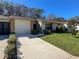 Inviting villa featuring a neat lawn and attached garage at 6594 Brambleleaf Dr, Spring Hill, FL 34606