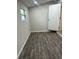 Spacious bedroom with dark wood-look tile flooring and neutral walls at 7142 Carlow St, New Port Richey, FL 34653