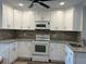 Bright kitchen featuring white cabinets, granite countertops, and modern appliances at 7142 Carlow St, New Port Richey, FL 34653