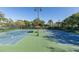 Two well-maintained tennis courts with seating area at 9728 Milano Dr, Trinity, FL 34655