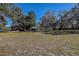 Open backyard with a home and trees in the background at 10525 Hilltop Dr, New Port Richey, FL 34654