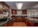 Spacious kitchen featuring dark wood cabinets and granite countertops at 10525 Hilltop Dr, New Port Richey, FL 34654