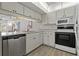 White kitchen cabinets and granite countertops with stainless steel appliances at 12141 Spartan Way # 204, Hudson, FL 34667