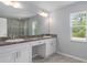 Double vanity bathroom with white cabinets and a large mirror at 12396 Barnevelde Rd, Weeki Wachee, FL 34614