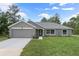 Gray house with a two-car garage and a well-manicured lawn at 12396 Barnevelde Rd, Weeki Wachee, FL 34614