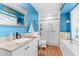 Well-decorated bathroom with blue walls, a shower, a modern vanity, and a nautical theme at 1249 Mazarion Pl, Trinity, FL 34655