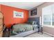 Comfortable bedroom features an orange accent wall and a tufted headboard at 1249 Mazarion Pl, Trinity, FL 34655