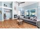 Bright living room with fireplace, ceiling fan, wood floors, and sliding glass doors to the lanai at 1249 Mazarion Pl, Trinity, FL 34655