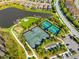 Aerial view showing tennis and pickleball courts near a lake and playground at 13022 Payton St, Odessa, FL 33556