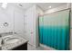 Bathroom with double sinks, granite countertops, and a teal shower curtain at 13022 Payton St, Odessa, FL 33556