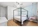 Bright bedroom with light blue accent wall, a canopy bed, and ceiling fan at 13022 Payton St, Odessa, FL 33556