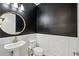 Powder room with pedestal sink, toilet, and black walls at 13022 Payton St, Odessa, FL 33556
