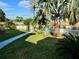 Waterfront backyard with lush landscaping and a white picket fence at 1354 Linstock Dr, Holiday, FL 34690